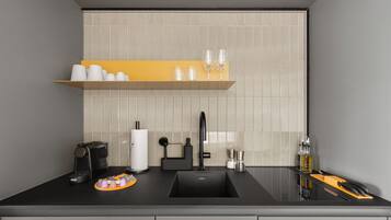 A modern kitchen with a black countertop, a sink, a coffee machine, and a knife block.