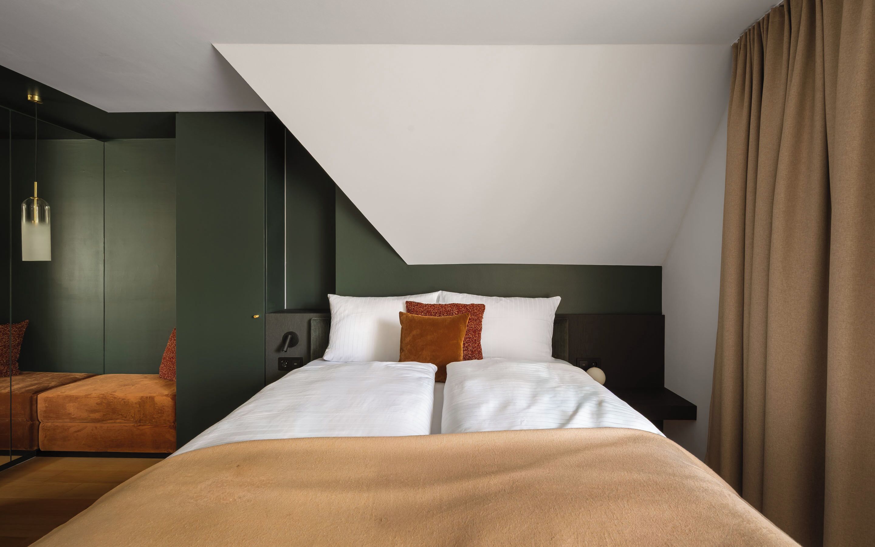 Une chambre d’hôtel moderne, équipée d’un lit, d’une table de chevet, d’une lampe et offrant une vue sur le ciel.