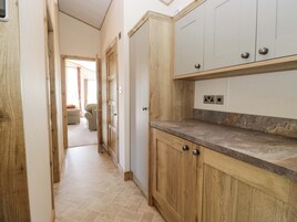 Una cocina con armarios de madera, una encimera y un enchufe.