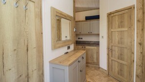 A hallway with wooden doors, a mirror, and a countertop. - Borwick Heights 17 (Carnforth)