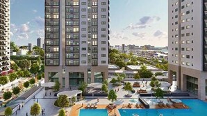 Un hotel di grandi dimensioni con numerosi piani, un'area piscina sul tetto e vegetazione circostante.