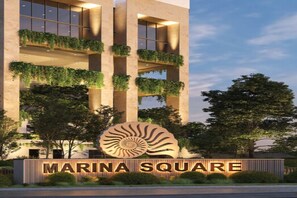A building with a sign reading 'MARINA SQUARE,' featuring a large shell logo, vertical garden balconies, and a modern architectural design. - Modern 3 bedroom Marina Square Retreat –Uptown Colombo (Colombo)