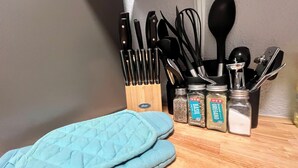 A kitchen counter with a knife block, a spice rack, and a blue oven mitt. - 2BDR+Extd Stay Discounts+Central+RemoteWork (Corpus Christi)