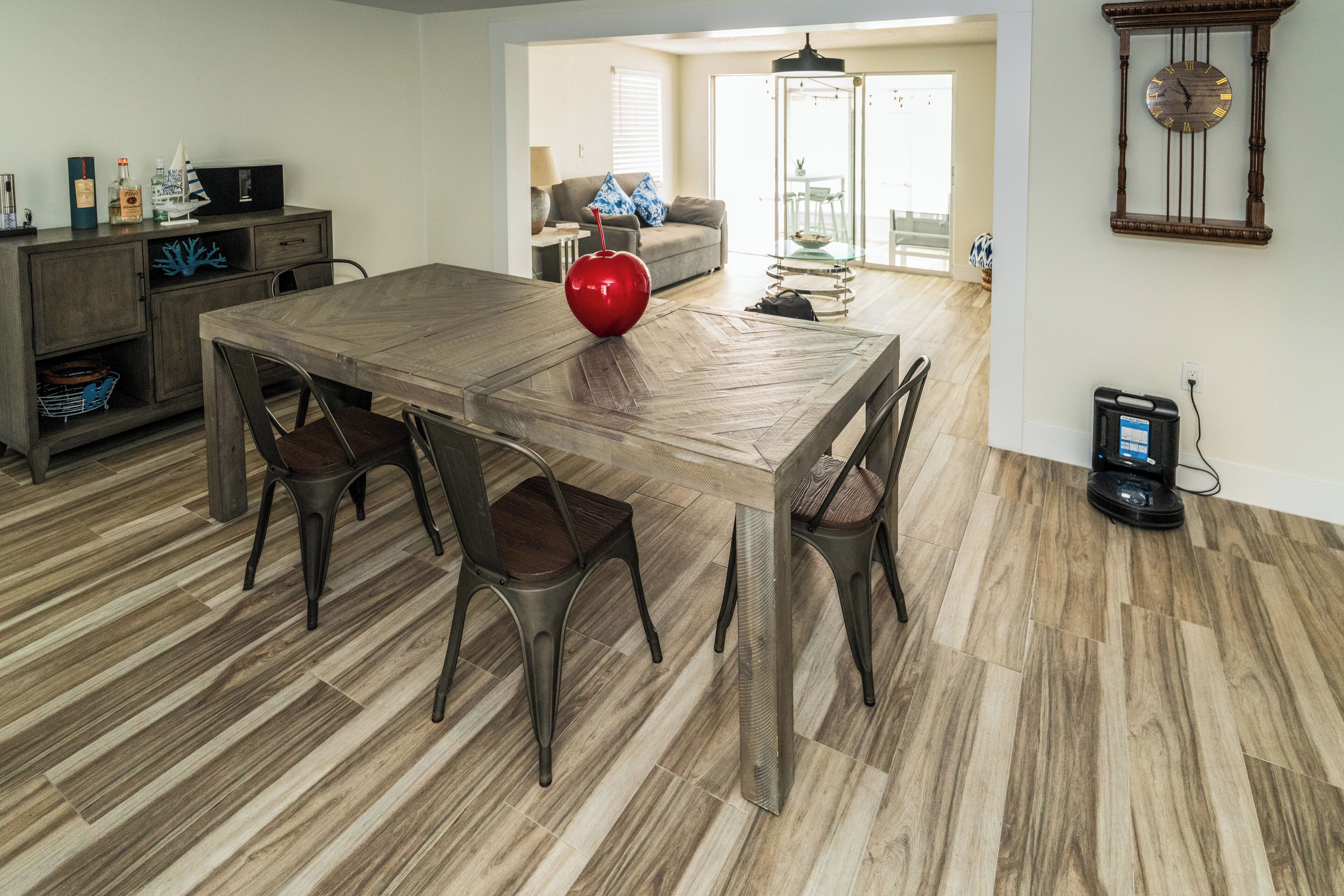 A dining area with a wooden table, chairs, and a red decorative item.