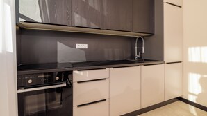 Una cocina moderna con horno empotrado, lavaplatos y campana extractora.