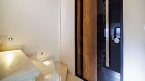 Una habitación con cama, una puerta de madera y una escalera.