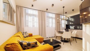 Una sala moderna con un sofá, una mesa de centro y un comedor con sillas y una mesa.