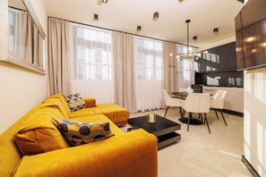 Ein modernes Wohnzimmer mit einer Couch, einem Couchtisch und einem Essbereich mit Stühlen und einem Tisch.