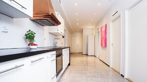 A modern kitchen with white cabinets, a black countertop, and a stainless steel range hood. - STAY Helsinki Center Apartment (Helsinki)