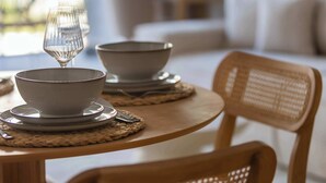 A dining table with a bowl, a glass, and a spoon. - Modern Apartment | Air Conditioning, Balcony, Underground Parking (Warszawa)