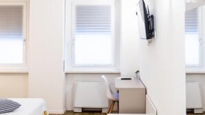 Una habitación pequeña con una cama, un escritorio y una silla.