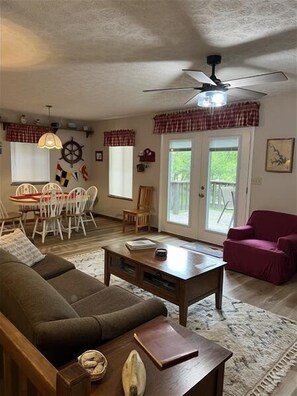A living room with a sofa, coffee table, dining table with chairs, and a ceiling fan. - Come Visit "Pirate's Roost'!  Pet Friendly! 2-3 Night Minimum! (Moneta)