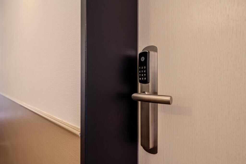 A modern door with a keypad lock and a metallic handle.
