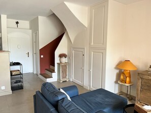 Ein Wohnzimmer mit einer Couch, einer Lampe und einer Treppe.