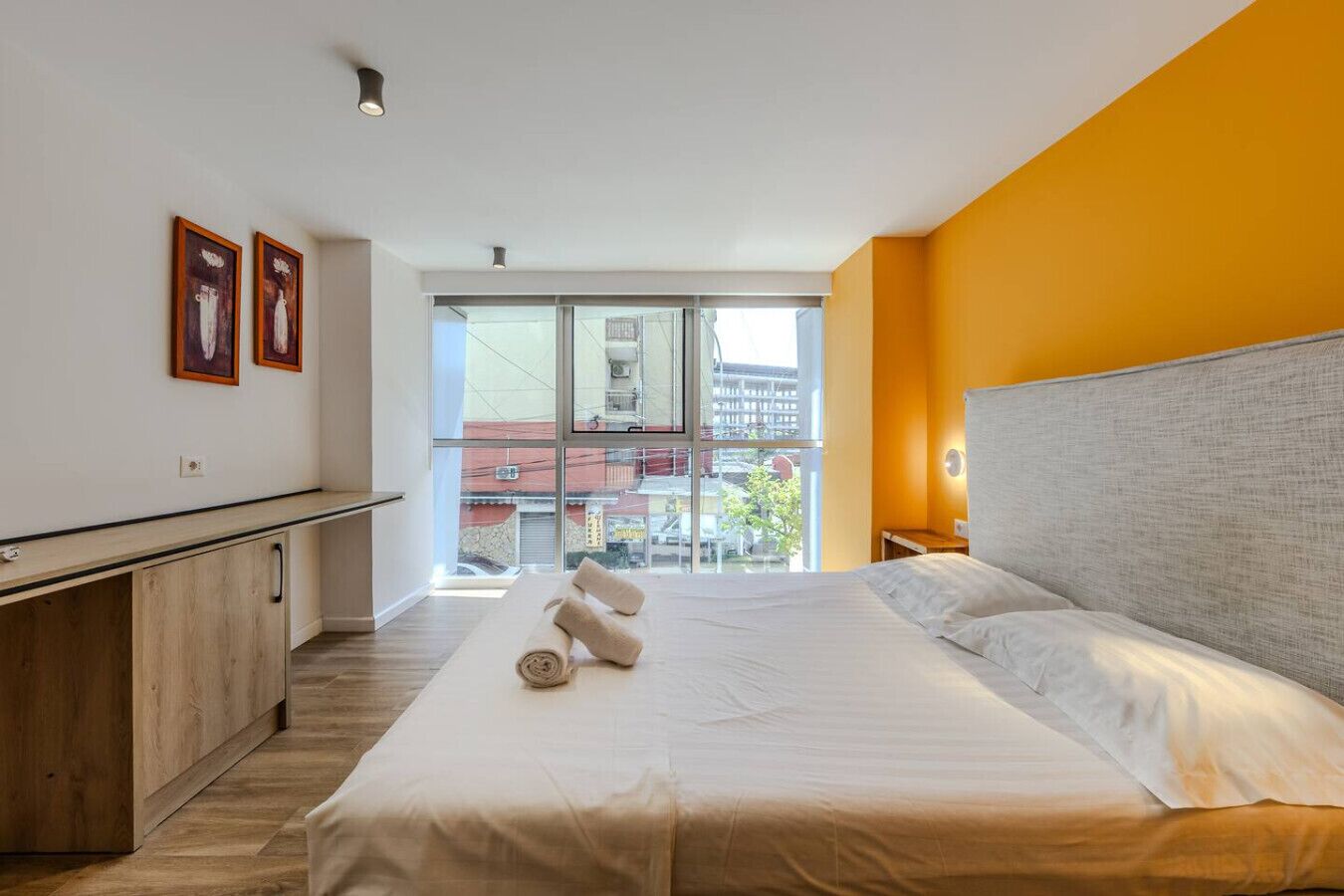 Une chambre d’hôtel moderne avec un grand lit, un bureau et une vue sur la ville.