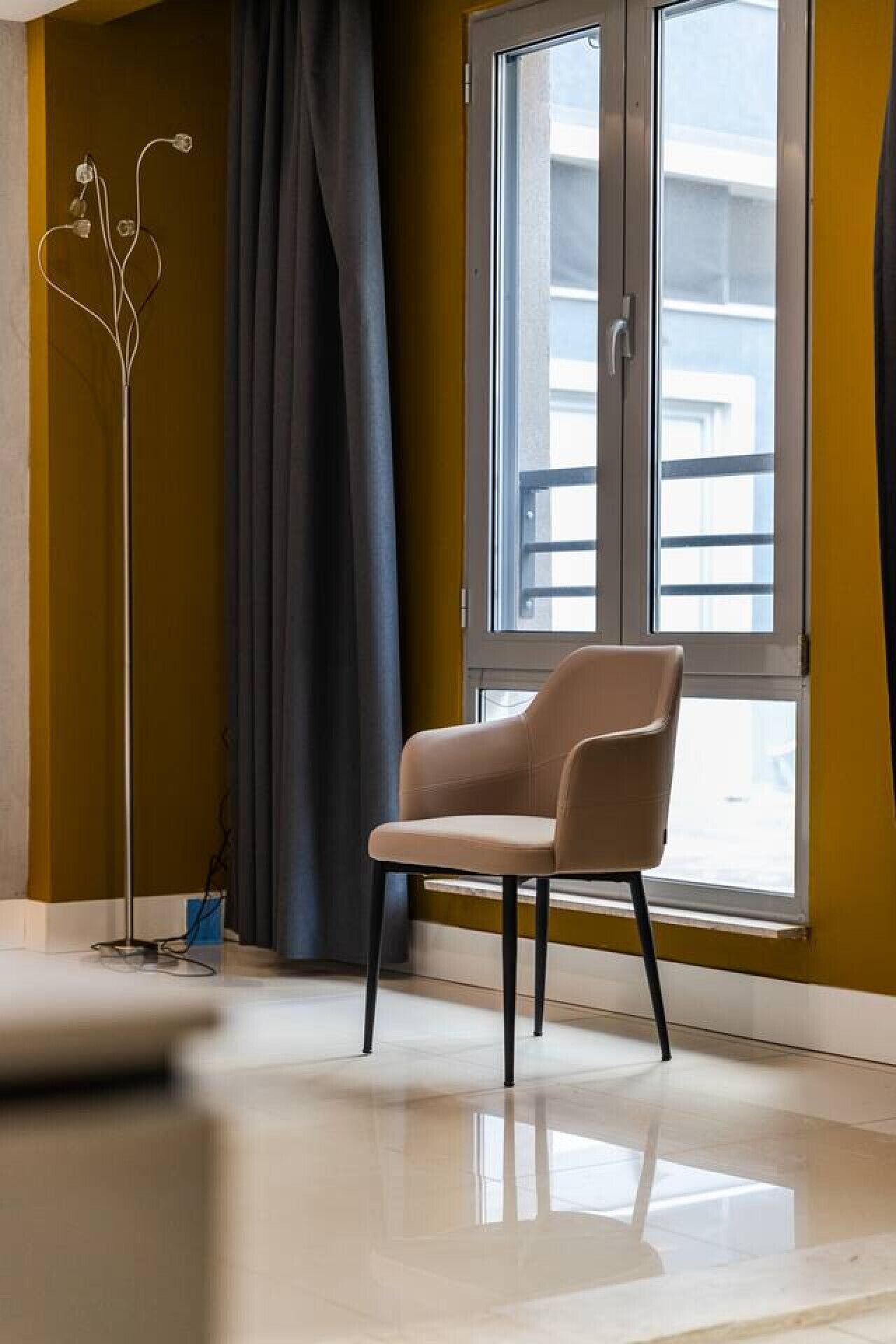 A modern room with a large window, a chair, and a floor lamp.