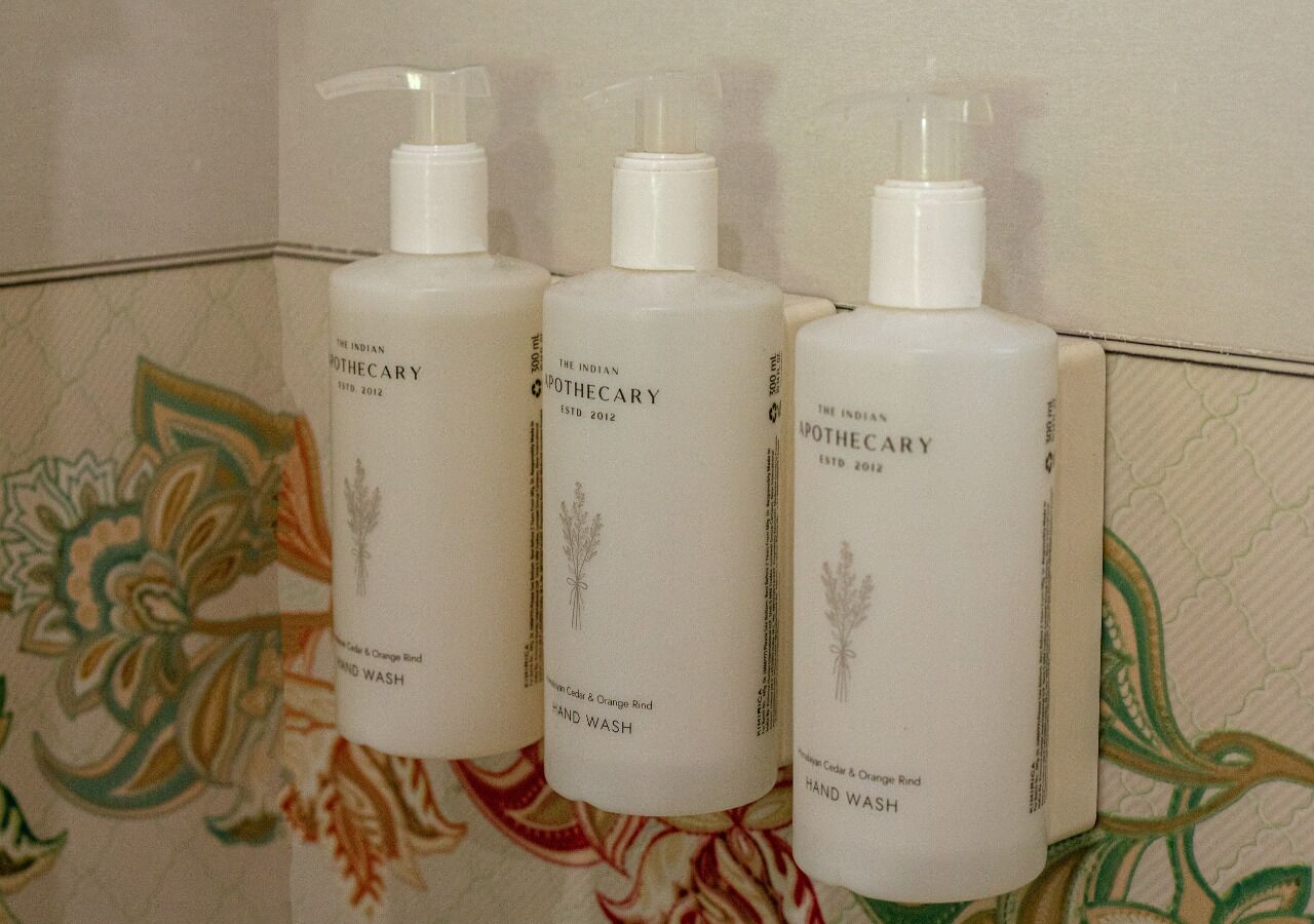 Trois bouteilles de savon liquide pour les mains, avec distributeurs à pompe.
