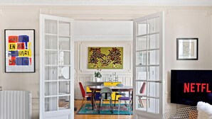 An open door leading to a dining area with a table, chairs, and a painting on the wall. - Luxurious apartment 3BDR/6P - Tour Eiffel (Paris)