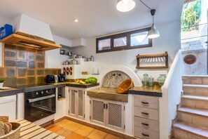 A compact kitchen with a built-in oven, a sink, and a window above the counter. - Cosy Townhouse with views (Pollensa / Pollença)