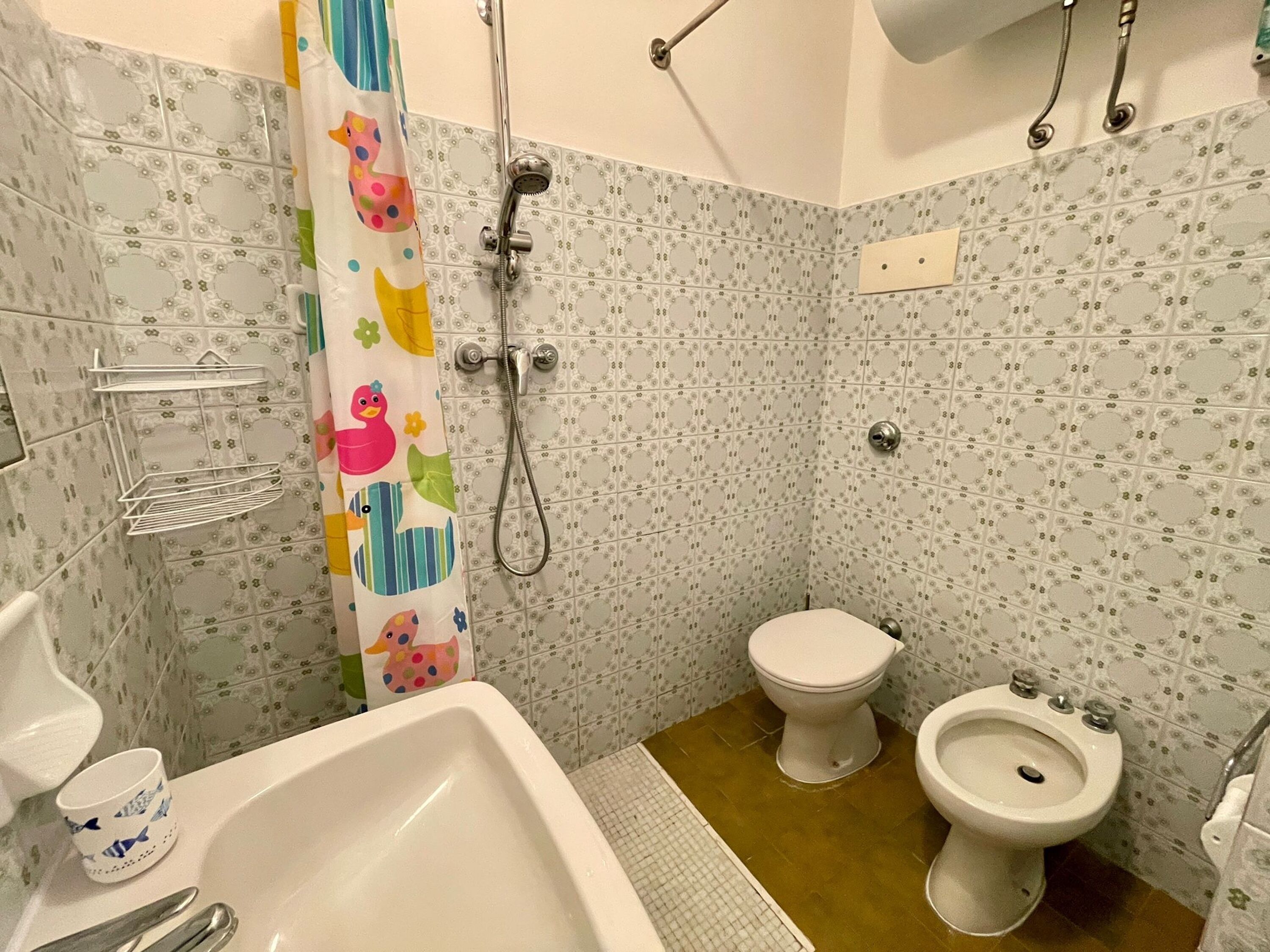 A bathroom with a shower, toilet, bidet, and a bathtub.