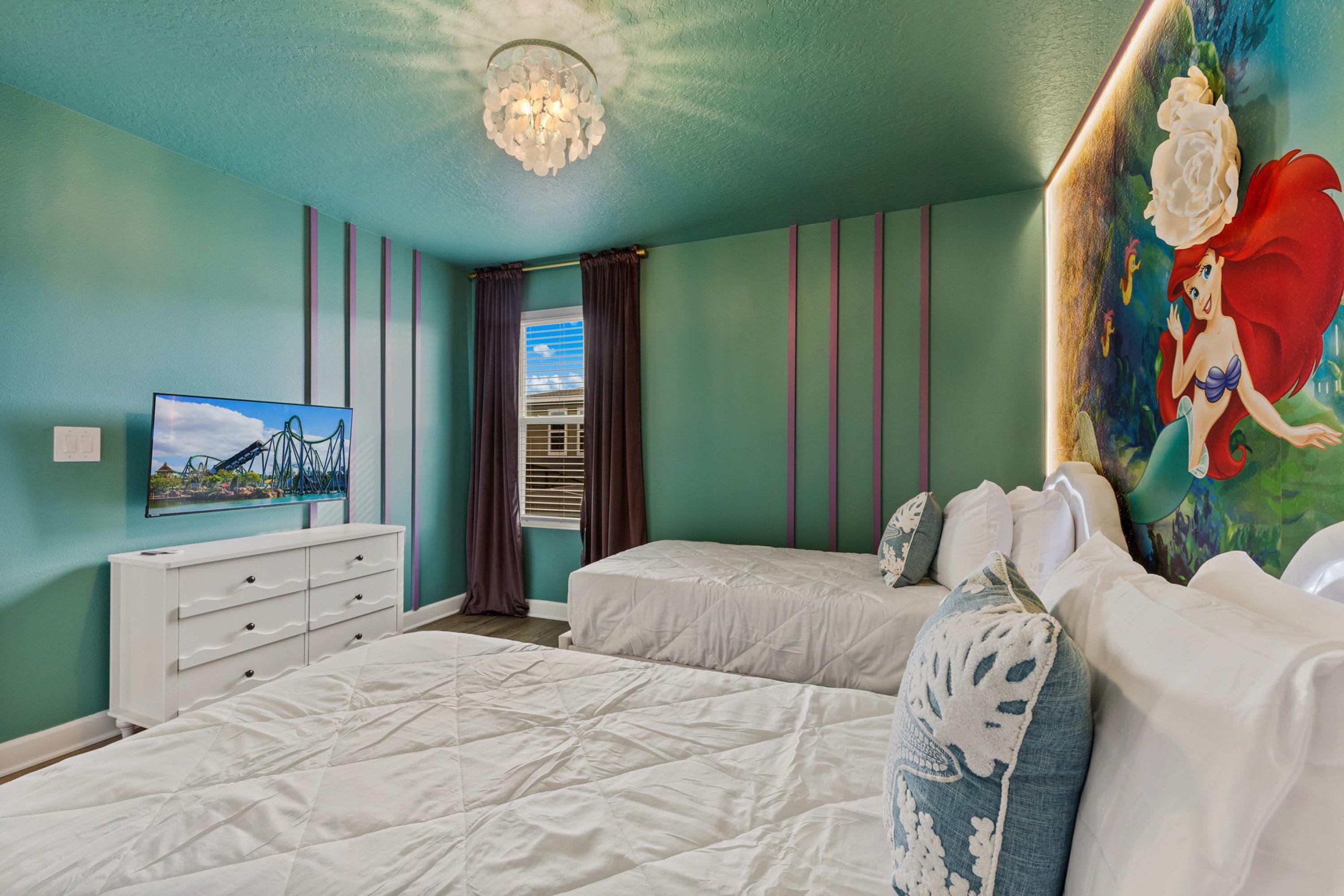 A bedroom with two beds, a dresser, a painting, and a television.