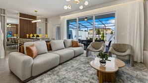 Ein modernes Wohnzimmer mit einer Couch, Sesseln, einem Couchtisch und einem Essbereich mit Blick.