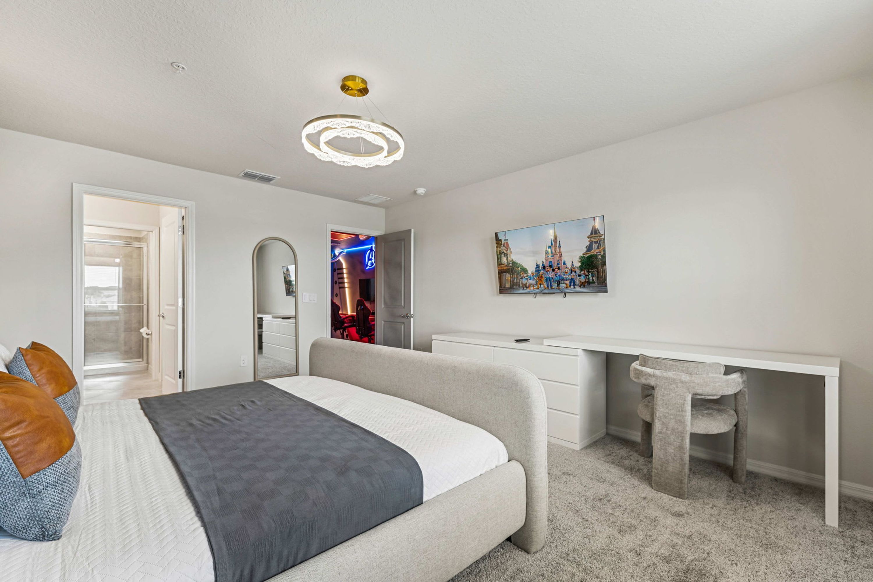 Ein Schlafzimmer mit einem Bett, einem Schreibtisch, einem Stuhl, einem Kleiderschrank und einem Bild an der Wand.