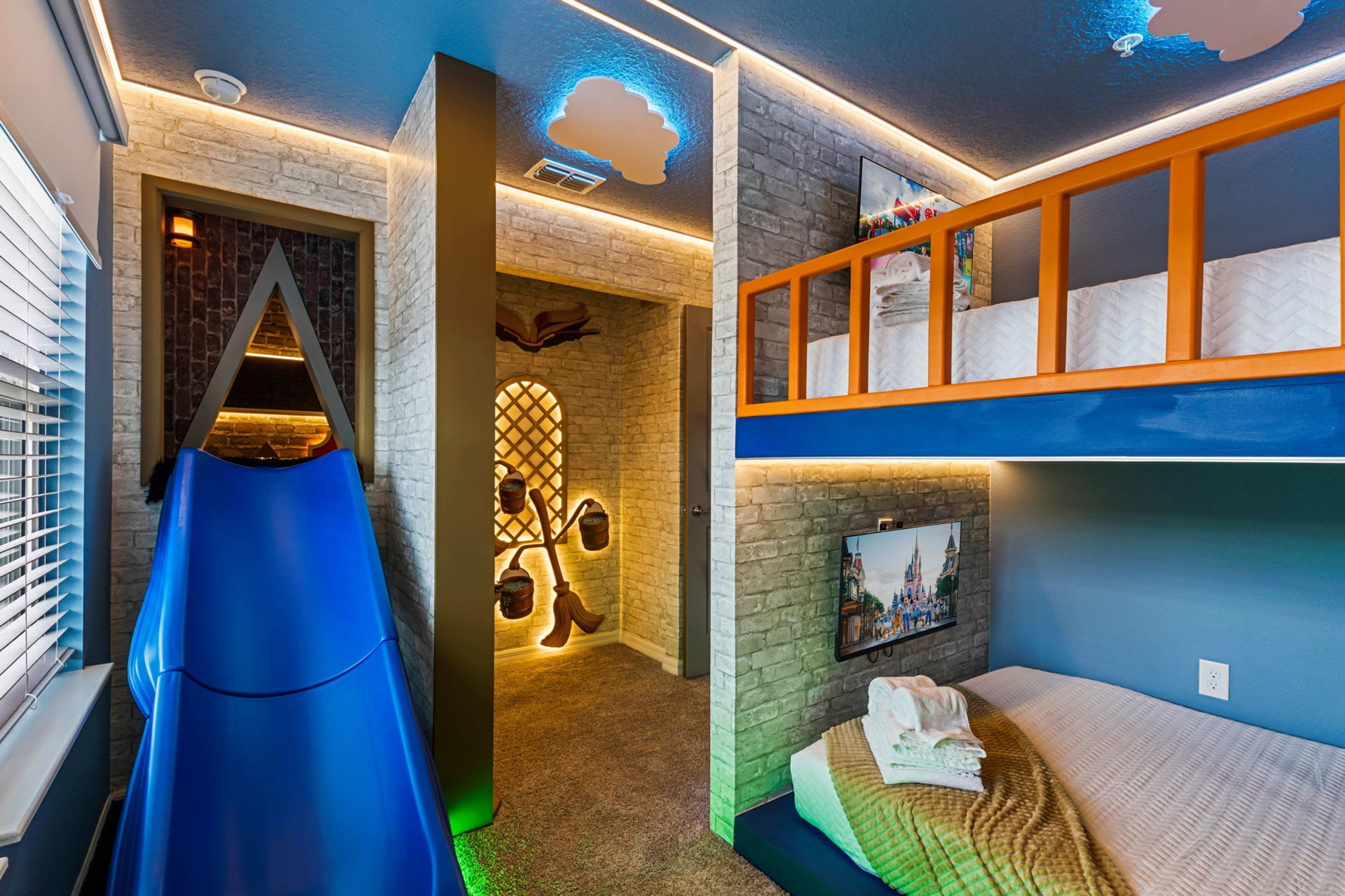 Een kamer met een stapelbed, een glijbaan en een bakstenen muur.