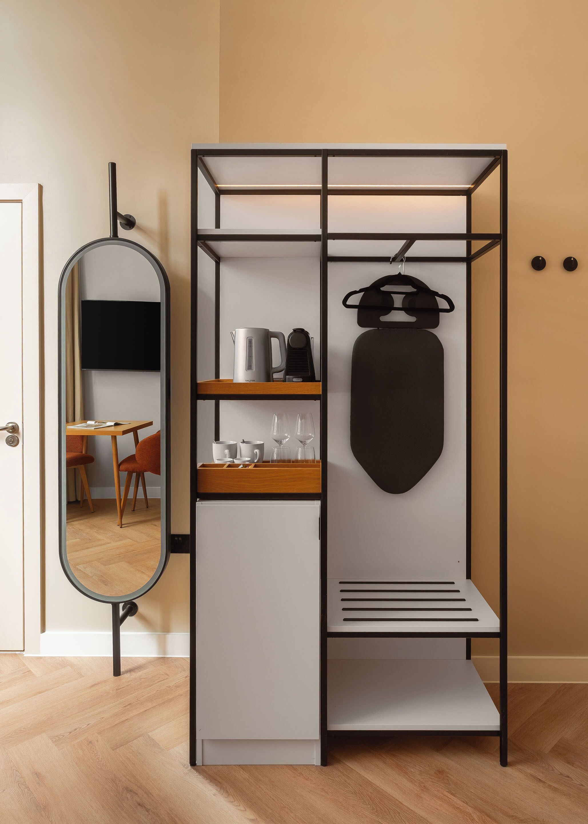 A compact room with a mirrored wardrobe, a small kitchenette, and a dining area.