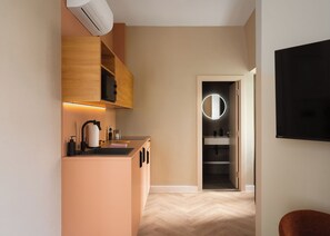 A modern kitchen with a built-in microwave, a sink, and a countertop with a kettle and soap dispenser. - Limehome London St. Paul's (London)