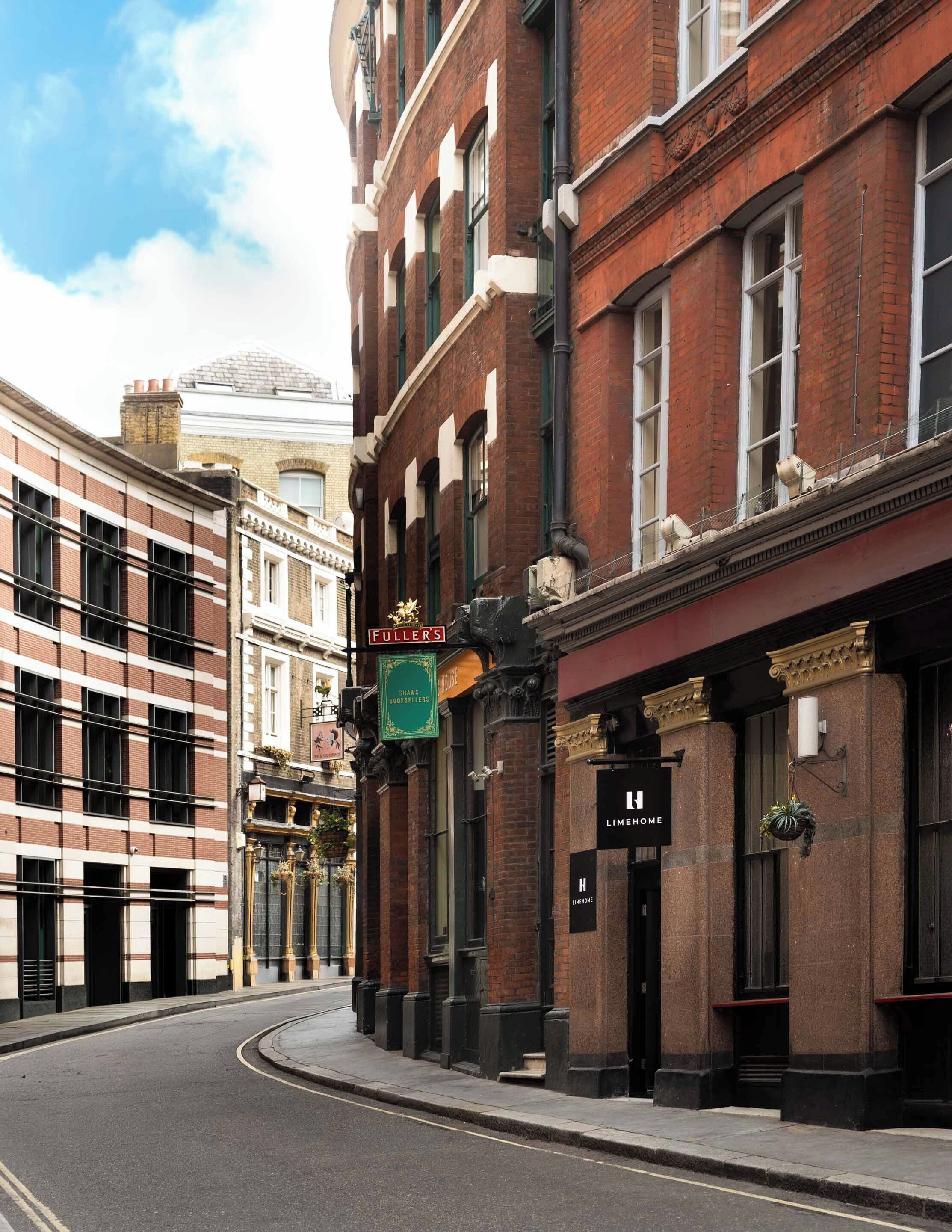 Vista de una calle con un edificio que muestra un letrero que dice 'Fuller's' y 'Shaws Booksellers'.