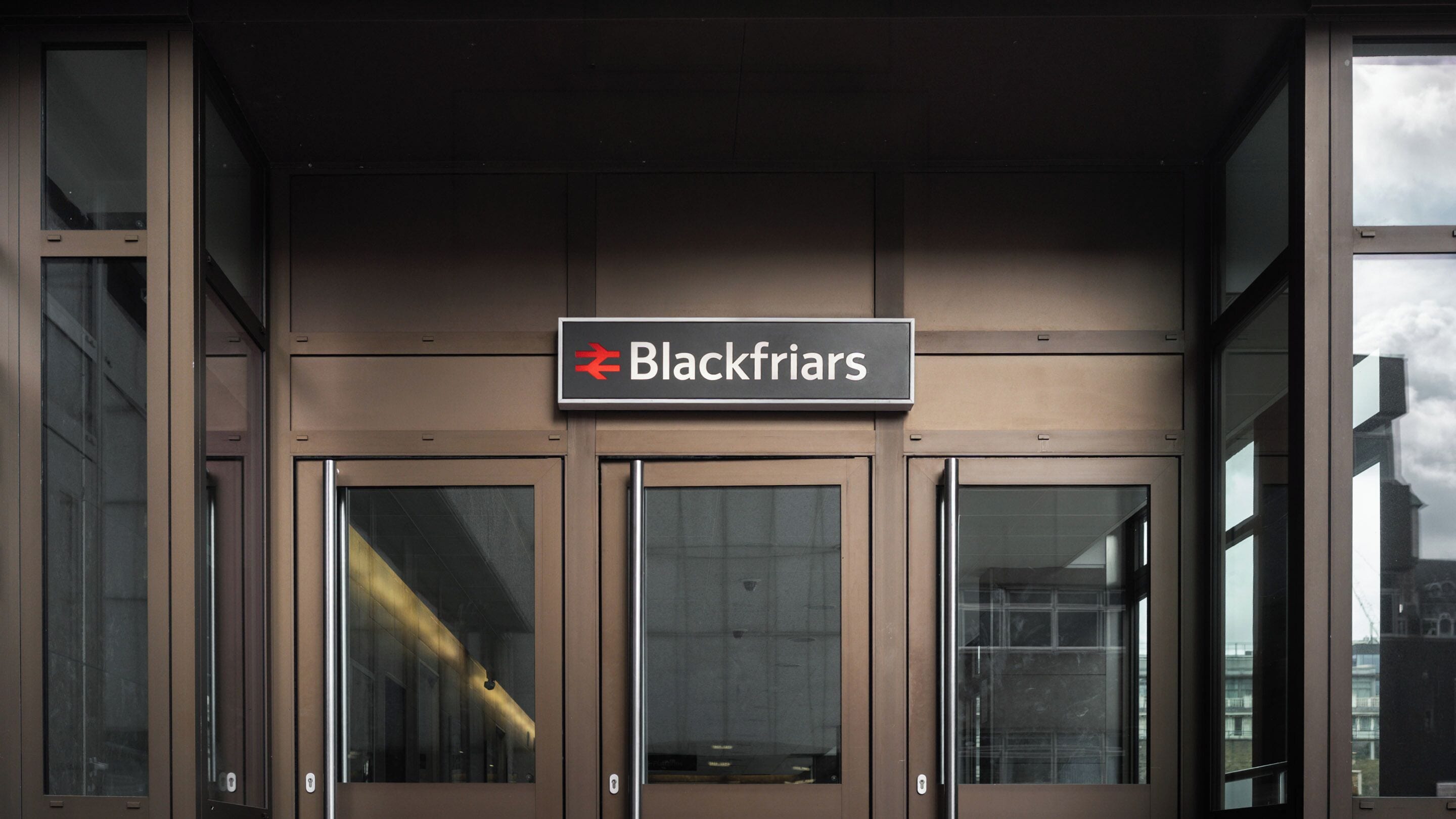Een gebouwtoegang met een bord waarop 'Blackfriars' staat en een paar dubbele deuren.