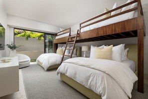 A modern hotel room with bunk beds, a desk, and a view of greenery. - Casa del Muelle in Punta Mita (Punta de Mita)