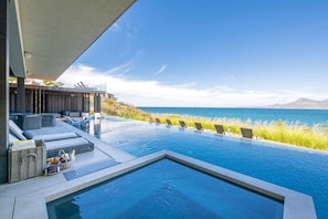 Ein Infinity-Pool mit Liegestühlen und Meerblick.