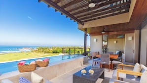 A modern outdoor lounge area with a pool, seating, and a view of the ocean. - Condo Ara in Punta Mita (Punta de Mita)