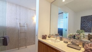 A modern bathroom with a shower, a vanity with a sink, a mirror, and a towel rack. - Condo Ara in Punta Mita (Punta de Mita)