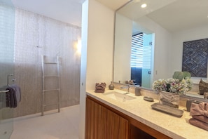 A modern bathroom with a shower, a vanity with a sink, a mirror, and a towel rack. - Condo Ara in Punta Mita (Punta de Mita)