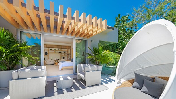 A modern outdoor living area with a bed, sofas, and a canopy. - Casa Brisa in Punta Mita (Punta de Mita)