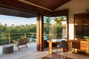 Ein moderner Außenbereich mit Glastür zum Balkon, einem Esstisch mit Stühlen und einer integrierten Unterhaltungsanlage.
