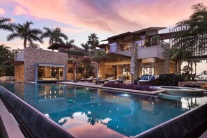 A modern resort with a swimming pool, outdoor seating, and a multi-level building with balconies. - Casa Herradura in Punta Mita (Punta de Mita)