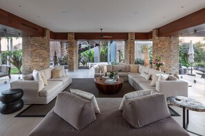 A spacious living area with a sectional sofa, a coffee table, and a view of the outdoors. - Casa Herradura in Punta Mita (Punta de Mita)