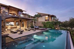 A modern house with a swimming pool, outdoor seating, and a stone facade. - Casa Herradura in Punta Mita (Punta de Mita)