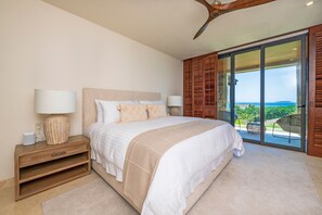A bedroom with a large bed, two bedside tables, a ceiling fan, and a view through a sliding glass door. - Condo Ensue o in Punta Mita (Punta de Mita)