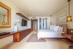 A modern hotel room with a large bed, a TV, a wooden console, a mirror, and a view of the hallway. - Condo Las Olas in Punta Mita (Punta de Mita)