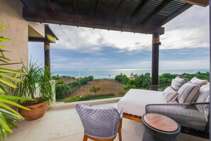 A balcony with a view of the sea, a sofa, a chair, and a potted plant. - Condo Las Olas in Punta Mita (Punta de Mita)