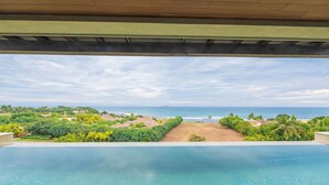 An infinity pool with a view of the ocean and a beach. - Condo Las Olas in Punta Mita (Punta de Mita)