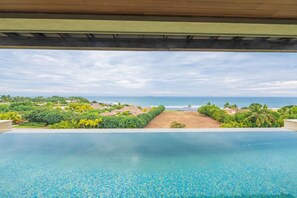 An infinity pool with a view of the ocean and a beach. - Condo Las Olas in Punta Mita (Punta de Mita)