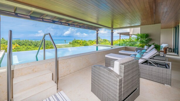 A rooftop pool area with wicker furniture, a glass infinity pool, and a view of the ocean. - Condo Balboa in Punta Mita (Punta de Mita)