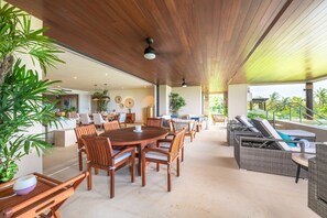 A spacious indoor area with a wooden ceiling, a dining table surrounded by chairs, and a seating area with lounge chairs. - Condo Balboa in Punta Mita (Punta de Mita)