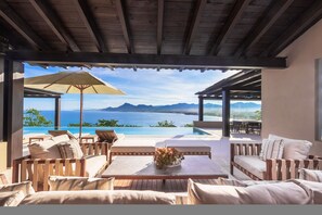 A covered outdoor seating area with a pool and a view of the sea. - Estate La Sierra in Punta Mita (Punta de Mita)
